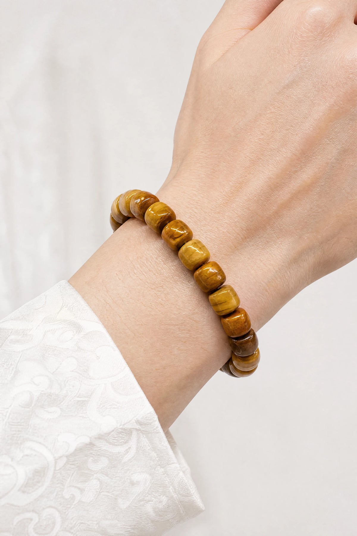 plain-orange-yak-bone-barrel-bracelet-model-a-outfit-a-closeup-01