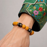 yellow-yak-bone-three-eye-dzi-bracelet-9mm-model-a-outfit-a-closeup-01